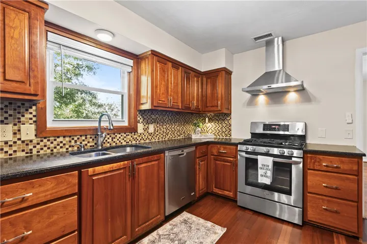 Rich wood cabinetry and sleek stone countertops ground this well-appointed culinary space.