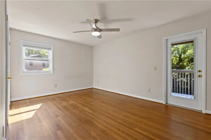Rich hardwood flooring anchors this versatile space featuring direct access to a private rear deck.