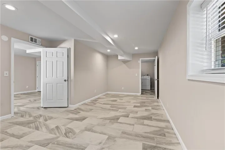 Polished tile flooring and recessed lighting define this versatile lower level living area.