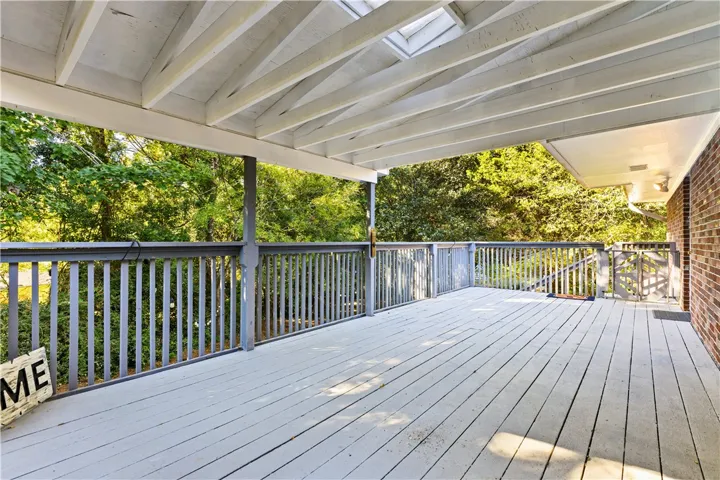 An elevated wood deck is sheltered by a vaulted beamed ceiling with integrated skylights.