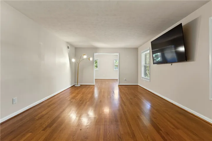 Gleaming hardwood floors run through this open living space into the adjoining room.