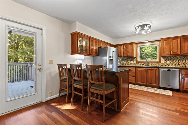 Warm wood cabinetry and flooring anchor this inviting kitchen with seamless outdoor access.