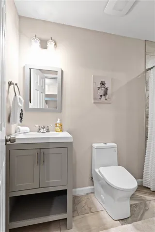 Tiled flooring and a modern vanity define this updated bathroom space.