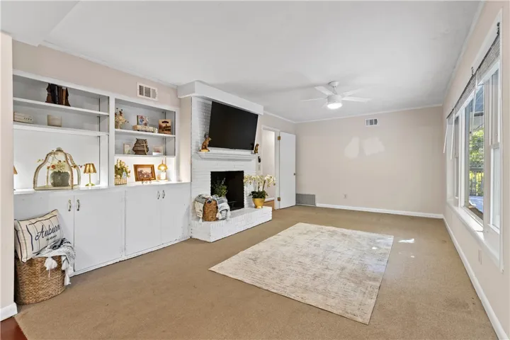 A classic brick fireplace and built-in shelving anchor this comfortable living area.