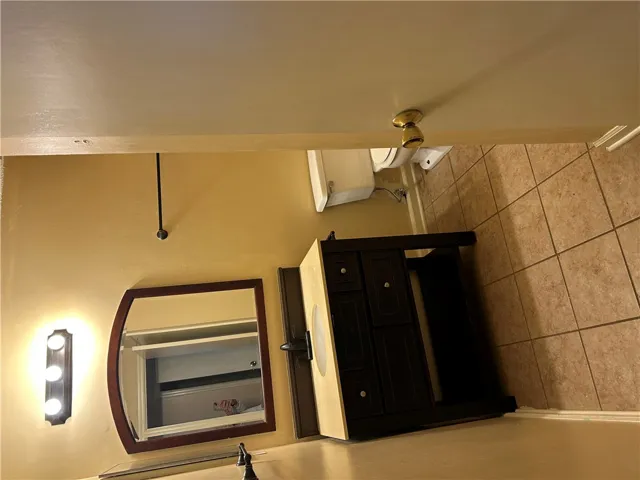 A classic vanity setup and neutral floor tiles define this functional half bathroom.