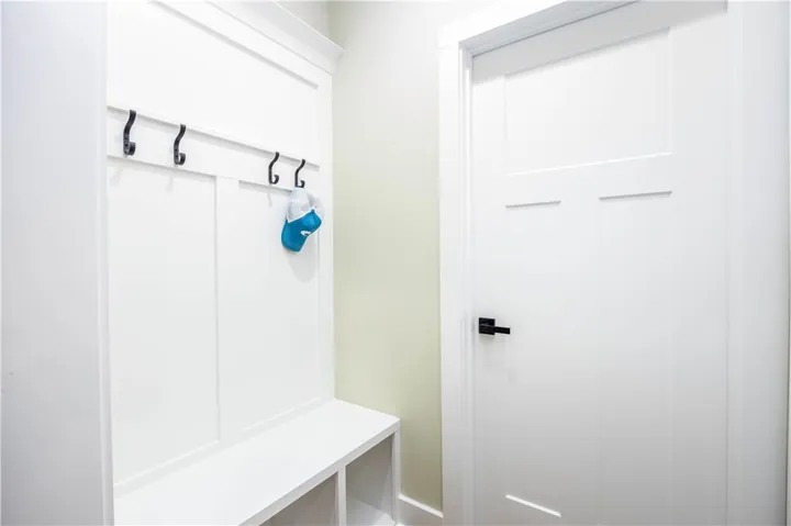 An organized mudroom area includes a built-in bench, storage cubbies, and classic wall paneling.