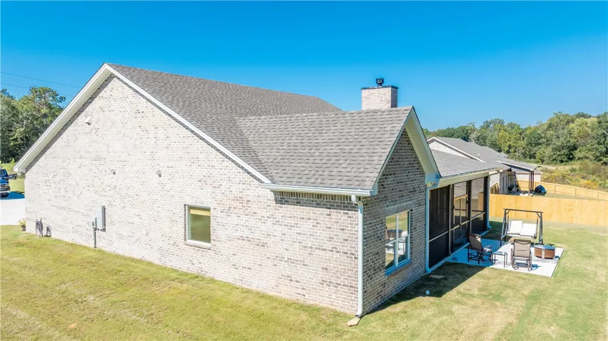 Brick exteriors and a multi-gabled shingle roofline define the rear profile of this home.