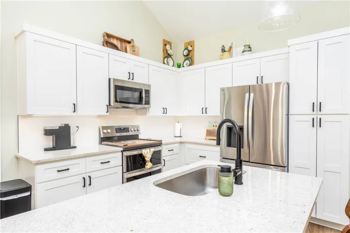 Crisp white shaker cabinetry and polished stone countertops elevate this modern cooking space.