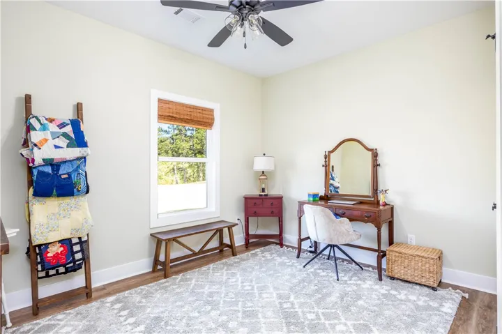 Gleaming hardwood floors and a large window framing serene outdoor views define this peaceful space.