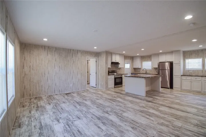 Textured plank flooring spans this airy open-concept living space and kitchen.