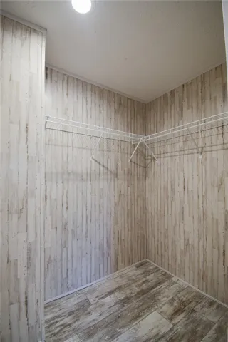 Functional storage space features plank-patterned walls and durable wood-look flooring.