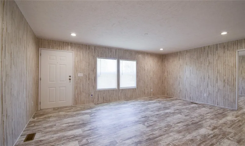 Textured wood-look paneling and durable vinyl plank flooring define this versatile main living area.
