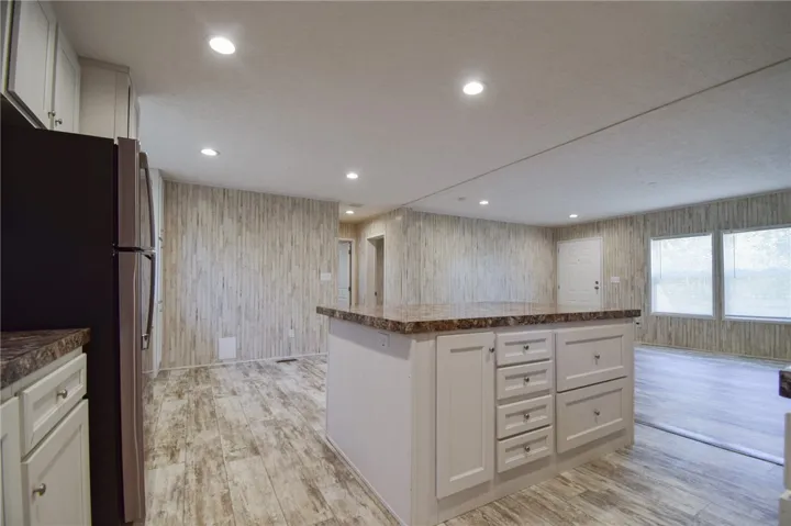 An open floorplan seamlessly connects the kitchen island to the bright living area.