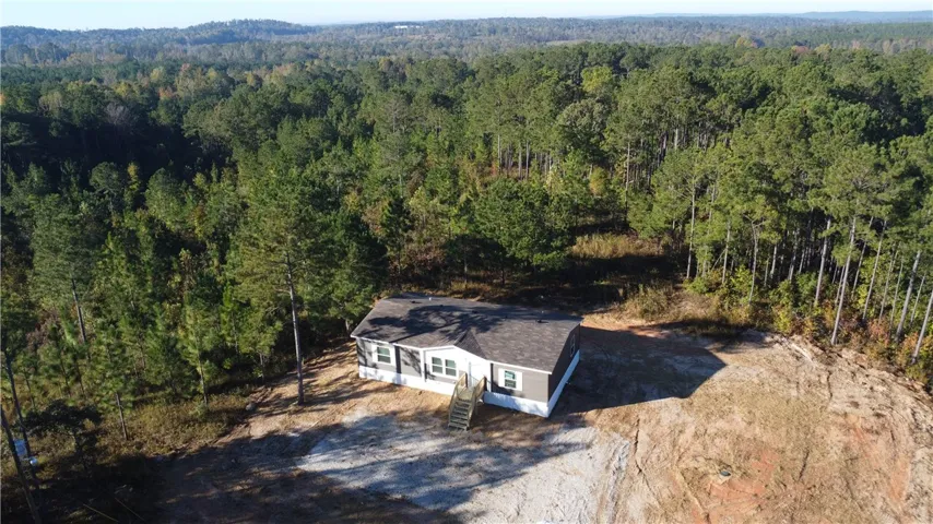 A secluded residential setting bordered by a dense forest canopy.