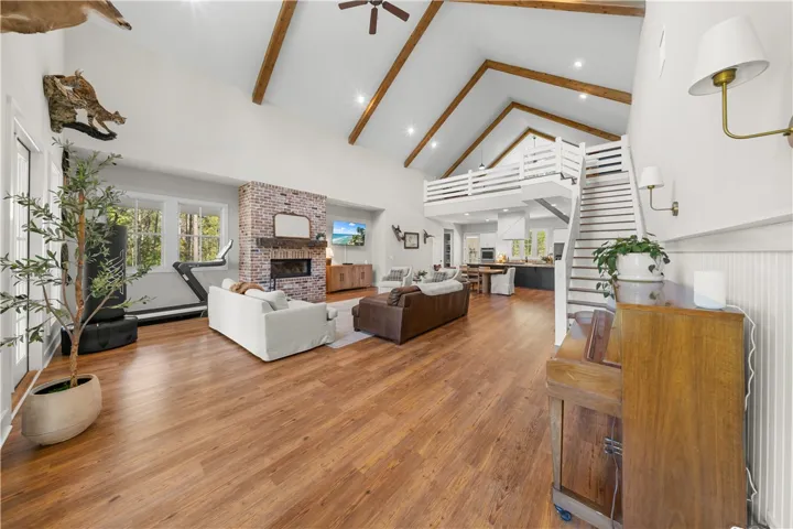 Dramatic exposed beams and a soaring brick fireplace anchor this airy open-concept living space.