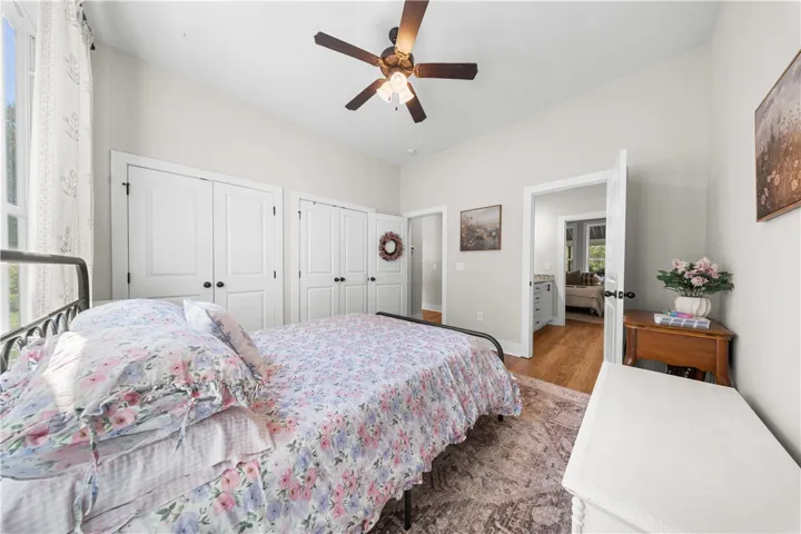 Hardwood floors and crisp white trim enhance this quiet bedroom with integrated closet space.