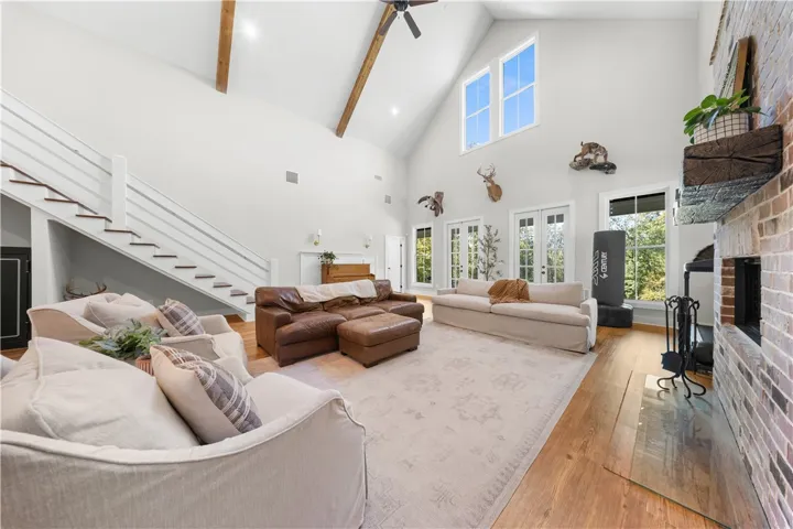 Towering vaulted ceilings and a brick fireplace anchor this grand two-story living space.