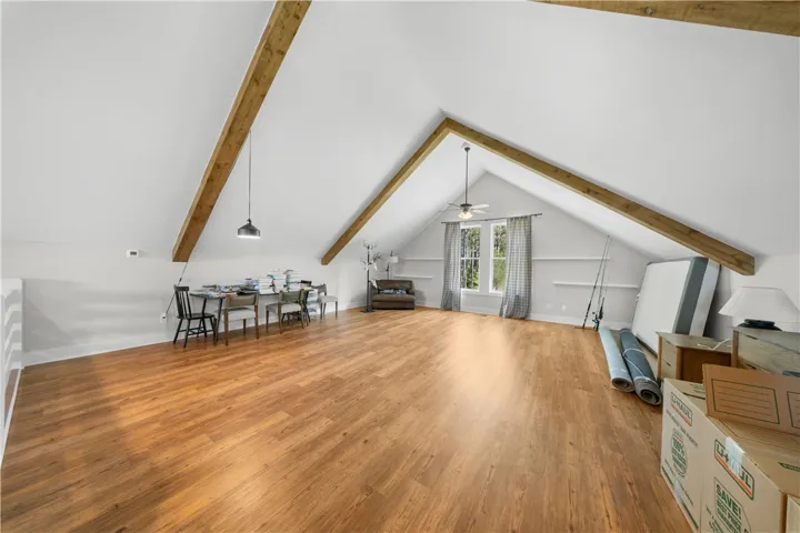 Striking architectural beams highlight the vaulted ceiling of this versatile upper-level bonus room.