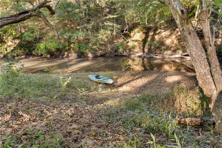 A tranquil flowing creek winds through dense mature trees on this scenic property.