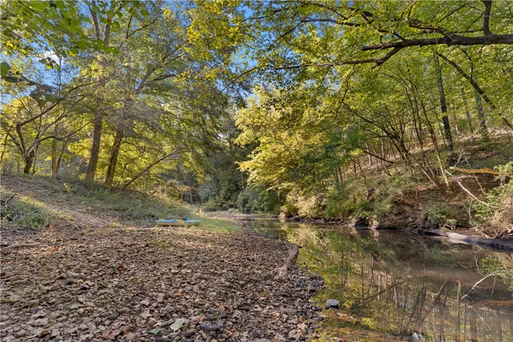 Mature trees line a peaceful flowing stream bordering the property.