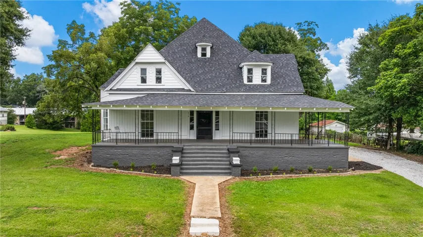 An expansive covered porch frames the symmetrical architecture of this classic two-story home.