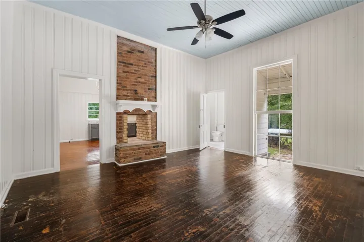 Rich hardwood floors and a brick fireplace create a warm, inviting focal point.