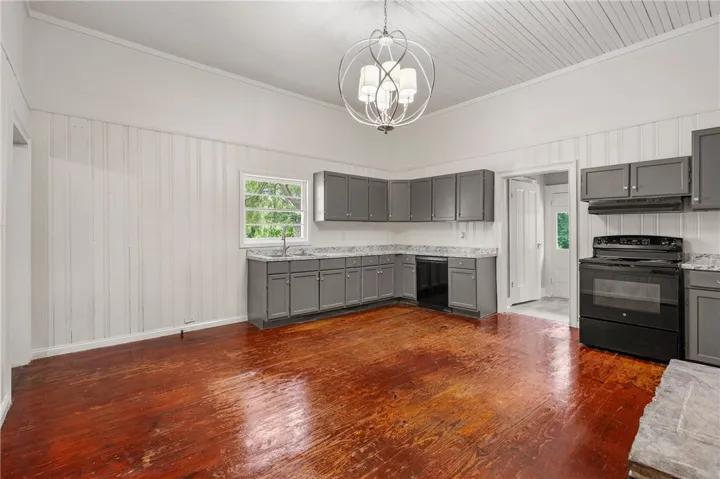 Rich hardwood floors complement the timeless wood-paneled walls in this airy, open kitchen.