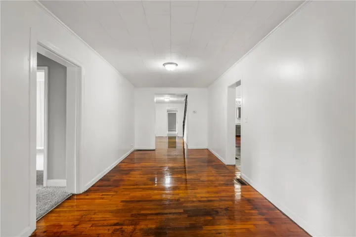Gleaming hardwood floors guide you down a wide hallway connects various living spaces.