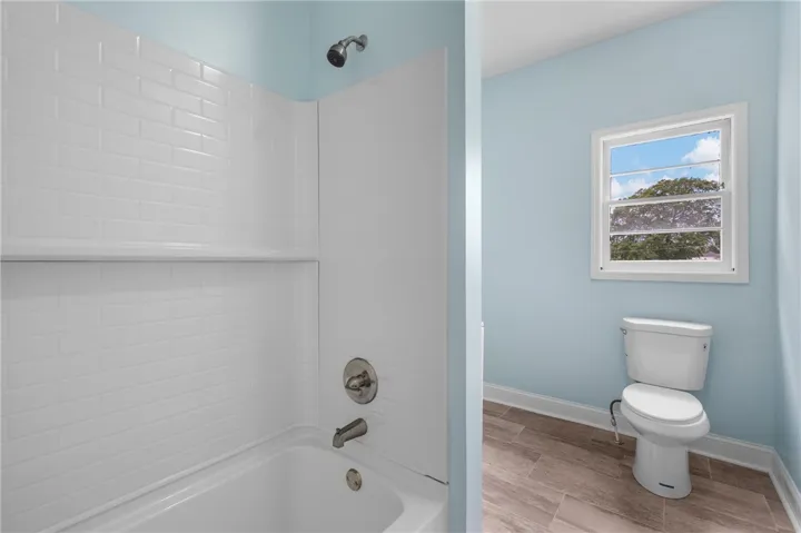 Crisp tiled tub surround and clean lines define this updated bathroom space.