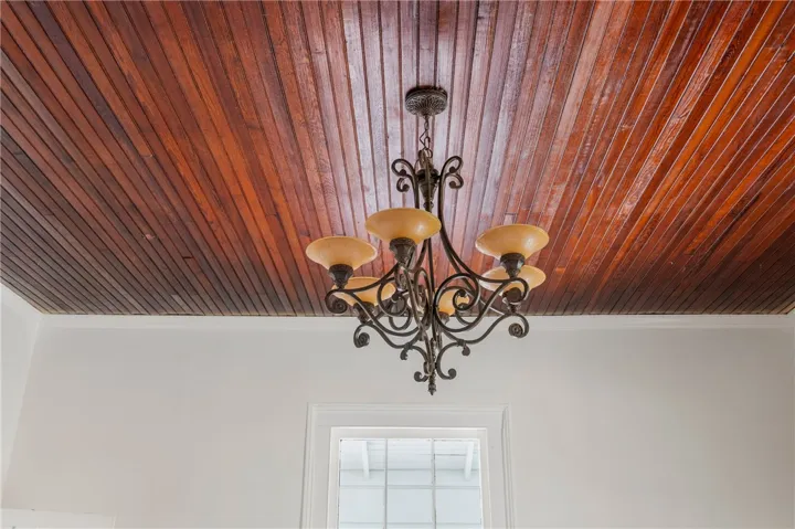 Rich wood plank ceilings contrast beautifully with the crisp white walls and elegant lighting.