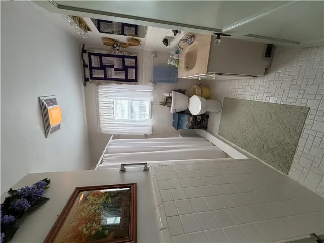 Functional bathroom space features tiled wall surrounds and classic sheet vinyl flooring.