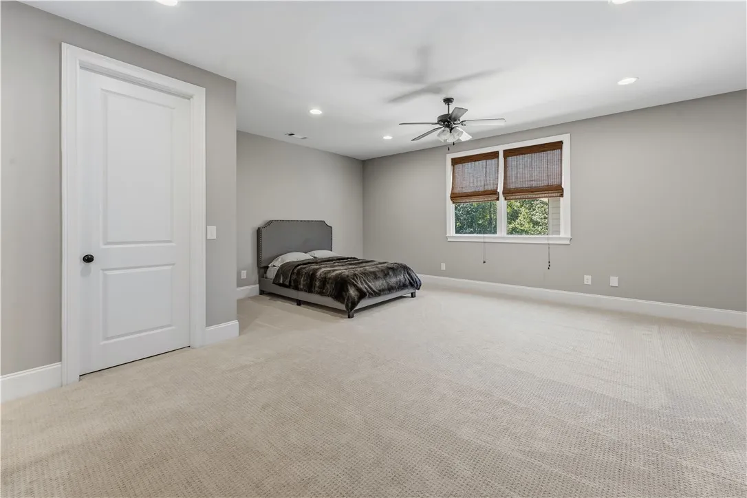 Plush carpeting and recessed lighting create a comfortable, quiet atmosphere in this bedroom.