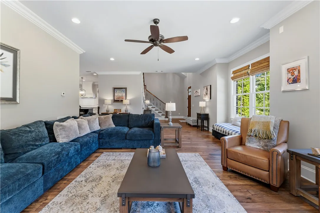 Gleaming hardwood floors and classic crown molding anchor this open living area.