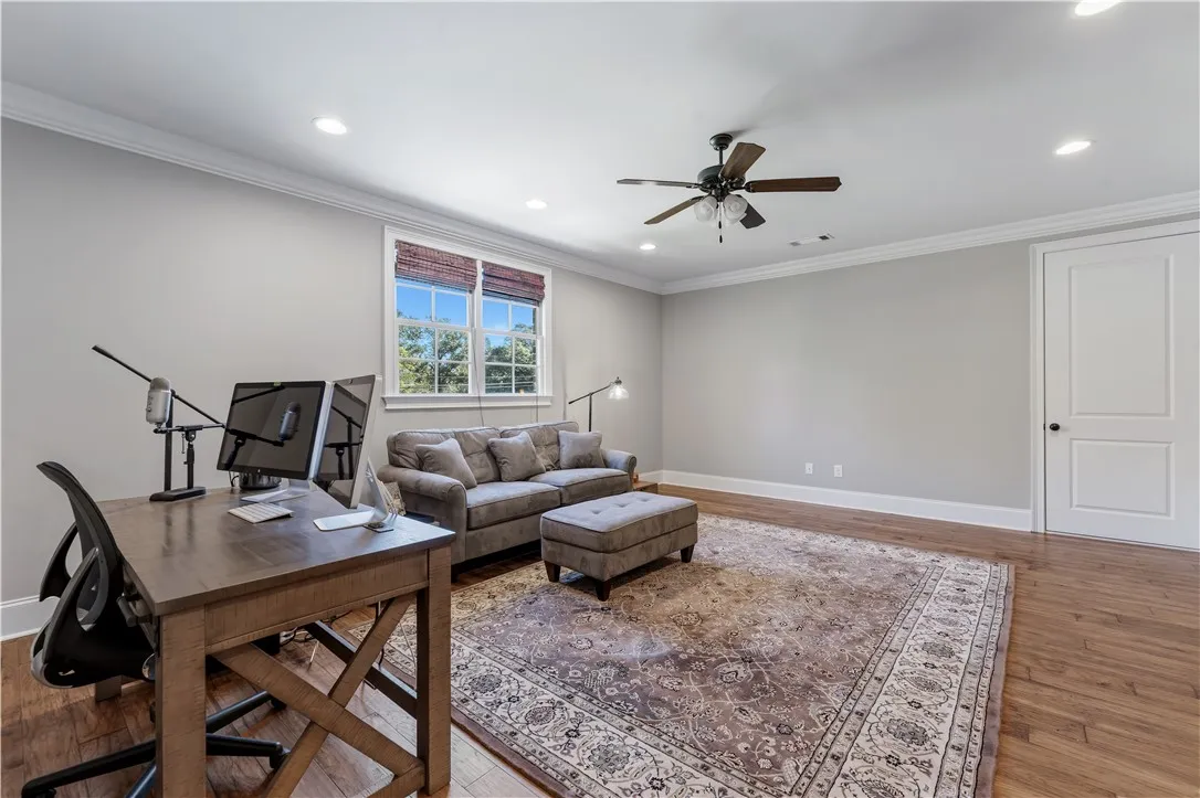 Warm hardwood floors and classic crown molding elevate this versatile interior space.