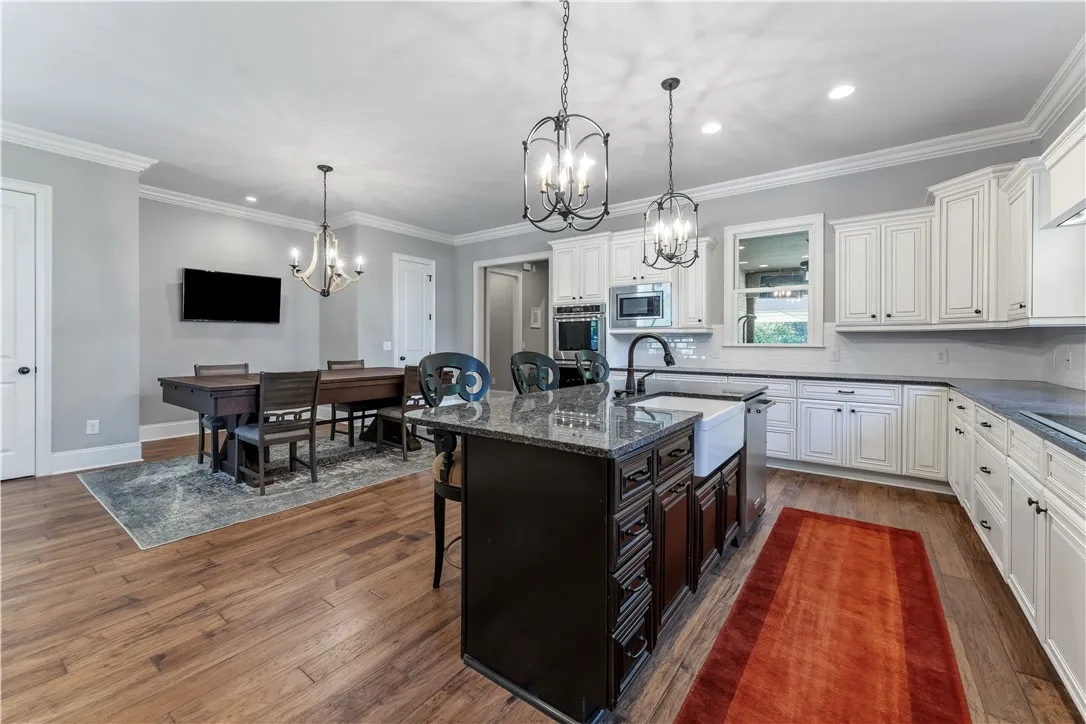 Gleaming hardwood floors and classic crown molding anchor this open-concept kitchen and dining space.