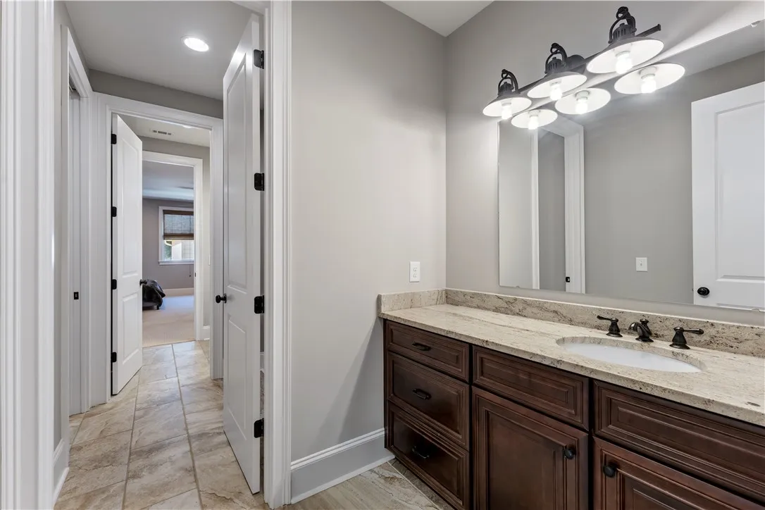Rich dark wood cabinetry pairs with neutral stone counters and classic tile floors.