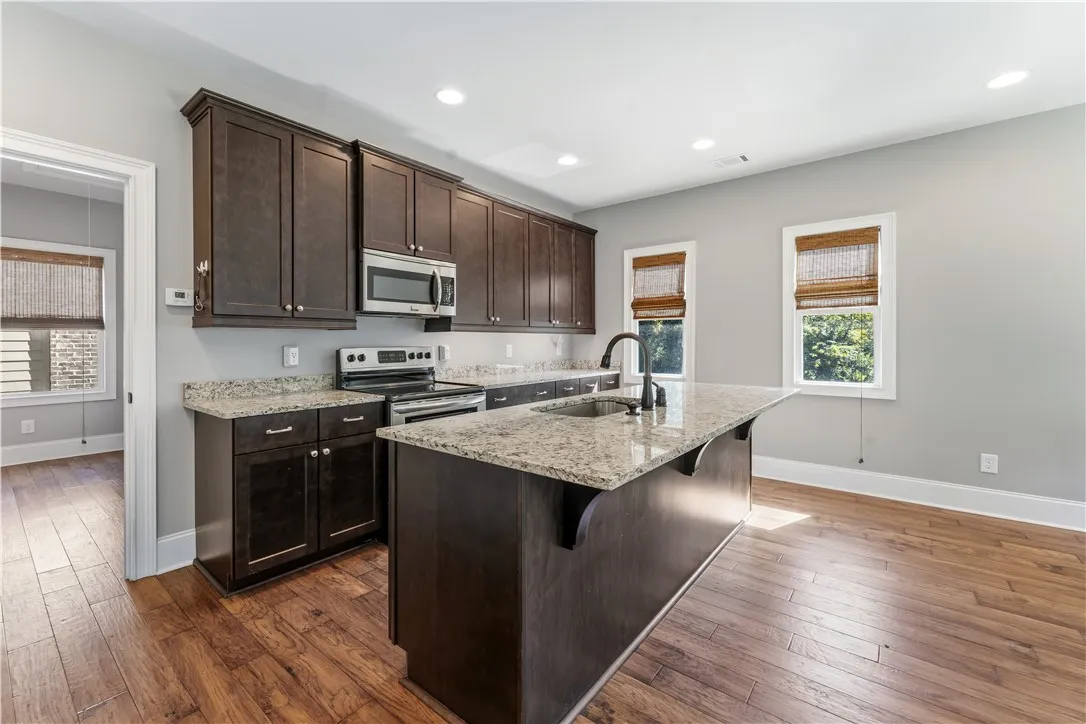 Rich wood cabinetry paired with granite countertops anchors this modern kitchen space.
