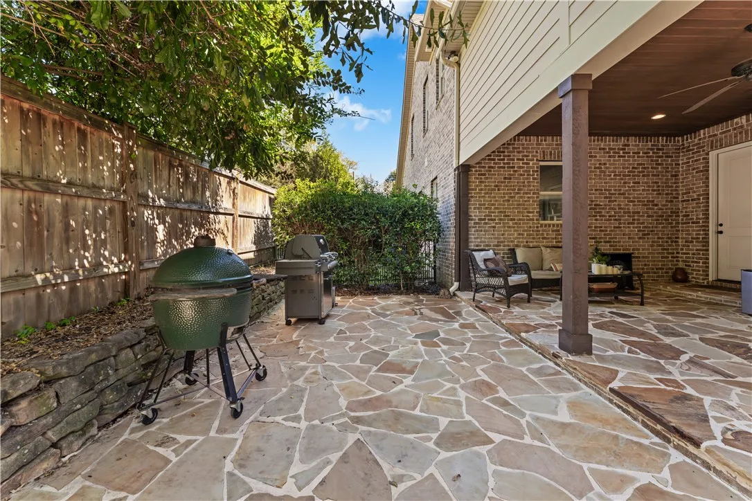 A spacious flagstone patio creates an inviting outdoor living area beneath a covered porch.