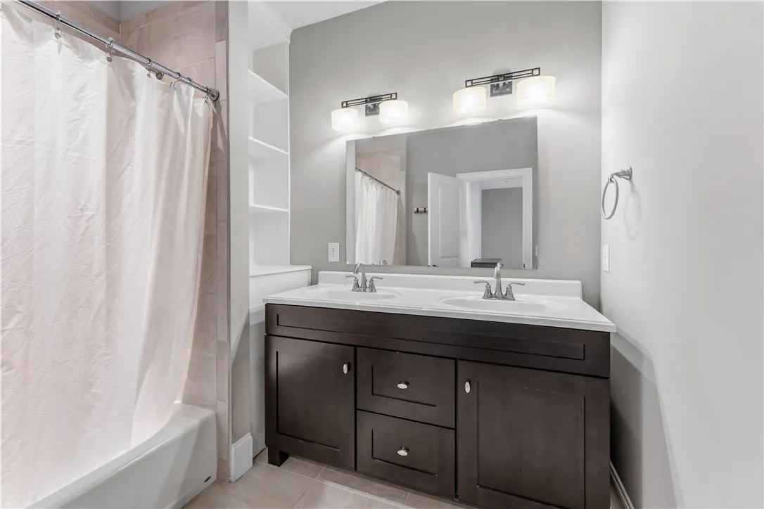 Clean lines and a dark wood double vanity anchor this refined bathroom space.