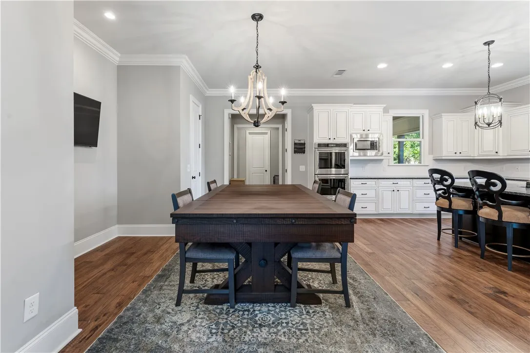 Gleaming hardwood floors and classic crown molding frame this elegant, open-plan dining space.