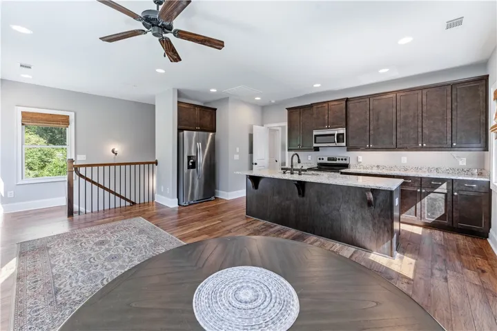 Rich hardwood flooring pairs beautifully with dark wood cabinetry and stone countertops.