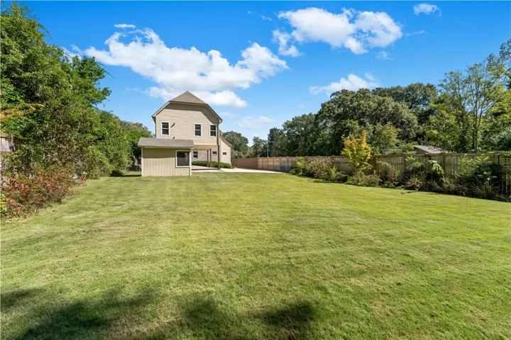 An expansive level lawn is fully enclosed by wooden privacy fencing under open skies.