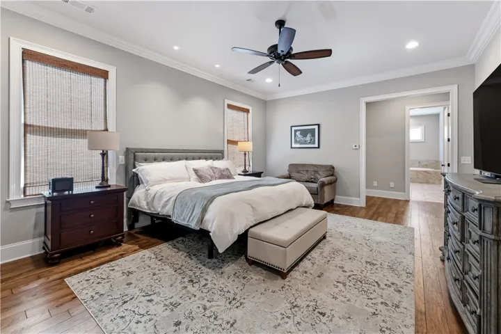 Hardwood floors and classic crown molding elevate this serene bedroom suite.