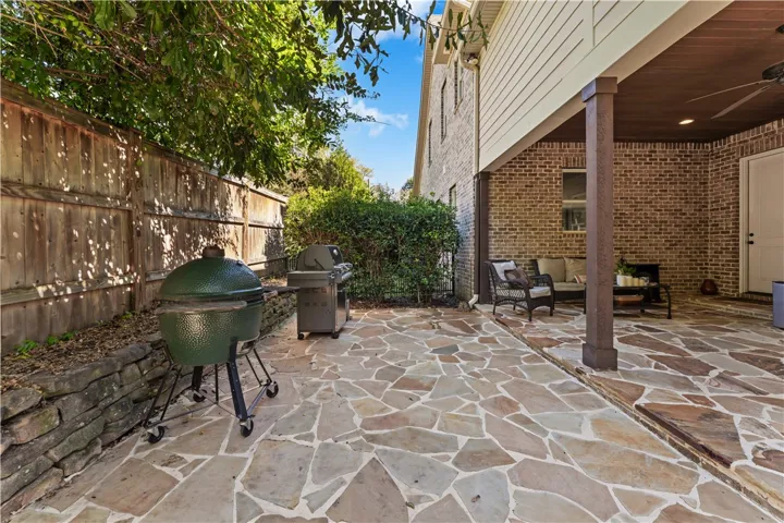 A spacious flagstone patio creates an inviting outdoor living area beneath a covered porch.