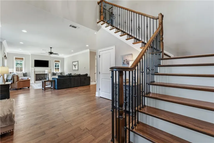 Rich wood floors and a custom staircase highlight this open-concept main-level design.