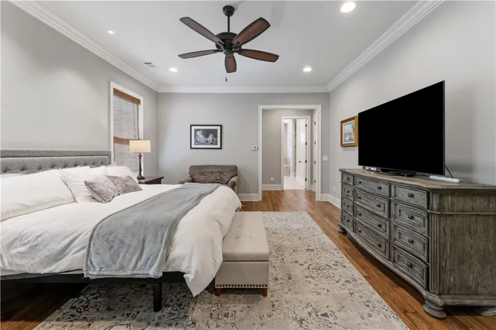 Rich hardwood flooring, classic crown molding, and recessed lighting create an inviting atmosphere.