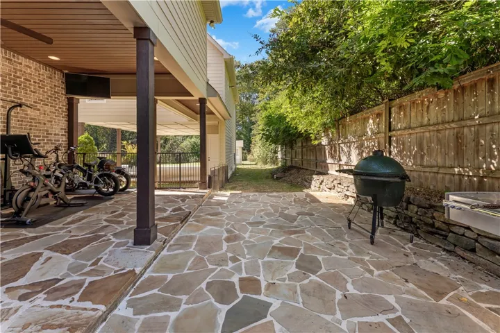 Natural flagstone pavers and brick accents line this covered backyard terrace.