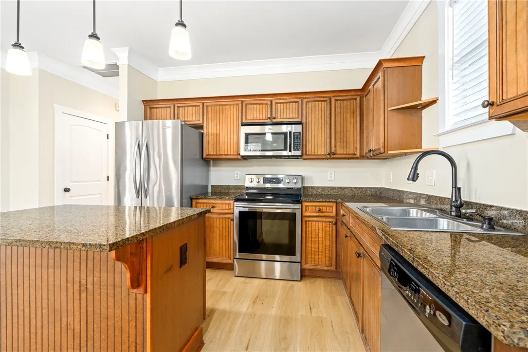 Granite countertops and classic wood cabinetry enrich this well-appointed kitchen space.