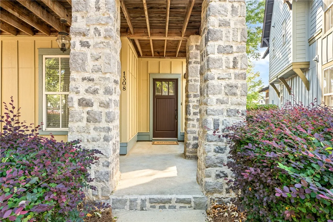 Stone pillars flank the welcoming entryway leading to a handsome craftsman-style front door.