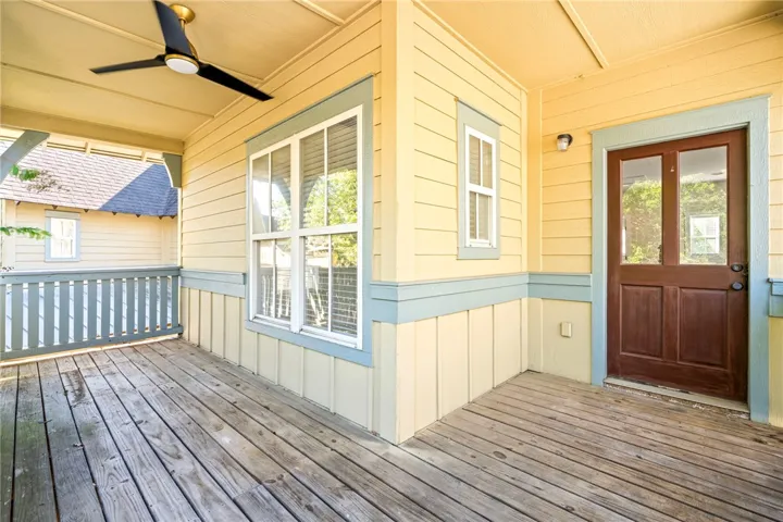 Wooden decking and detailed panel siding highlight this charming covered outdoor balcony.